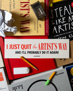 Stack of books including "Steal Like an artist", "The Creative Act: A way of being", and the 30th Anniversary edition of The Artist's Way with an 'I just quit The Artist's Way and I'll probably do it again' bumper sticker on top, surrounded by a pencil, eraser, pencil sharper and crumpled paper.