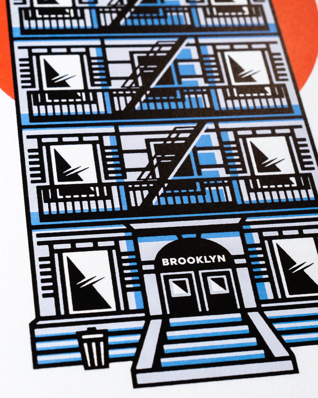 An 8"x10" art print of an illustrated NYC apartment building facade with repeated windows, fire escapes, and the word BROOKLYN above the entrance, shown on a white background with a small orange shape at the top left.
