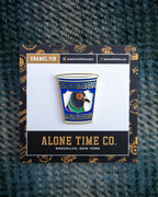 An enamel pin shaped like a blue and white Greek anthora cup with a pigeon head design, displayed on its branded backing card which reads 'ALONE TIME CO. BROOKLYN, NEW YORK'.