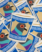 A close-up of multiple identical die-cut anthora cup stickers arranged on a light surface. Each sticker shows a stylized pigeon head with a red eye and multicolor plumage inside a cup-like shape with a blue Greek key border.