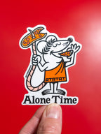 Die-cut vinyl sticker of an illustrated pizza rat character, reminiscent of the Little Caesar's mascot, holding a pizza on his tail while biting a slice, with 'Alone Time' text underneath, held against a red background.